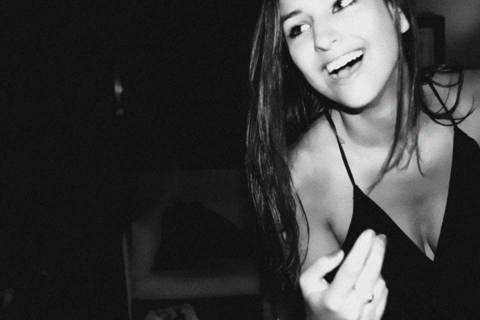 Black and white photo of a woman in a black dress with a blurred background