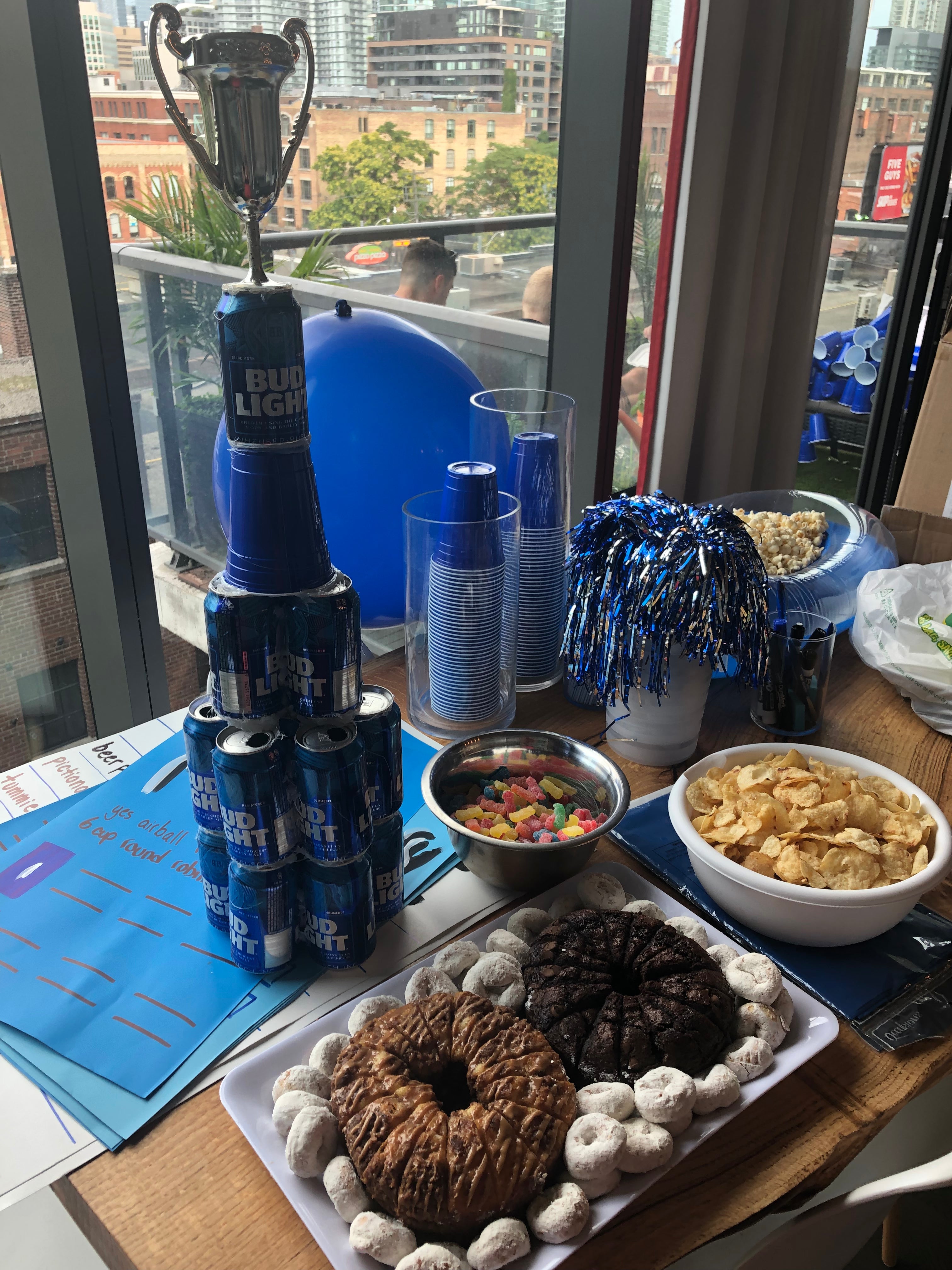 Table with snacks, drinks, and decor in front of a cityscape view