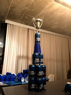 Trophy and beer bottles on a table with a curtain background