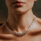 Close-up of a diamond necklace on a person's neck with a blurred background eviiq