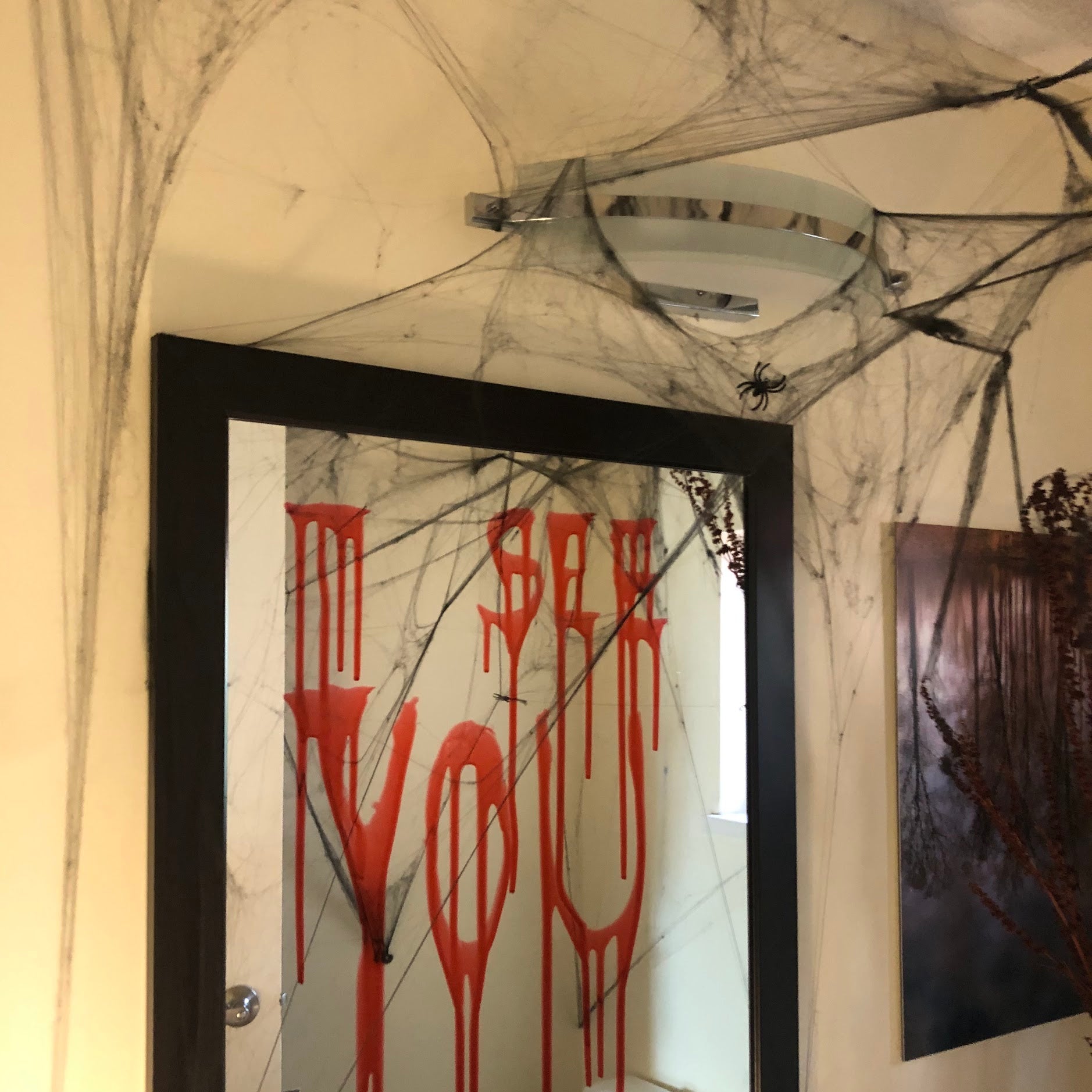 Decorative mirror with red text on a marble-patterned wall