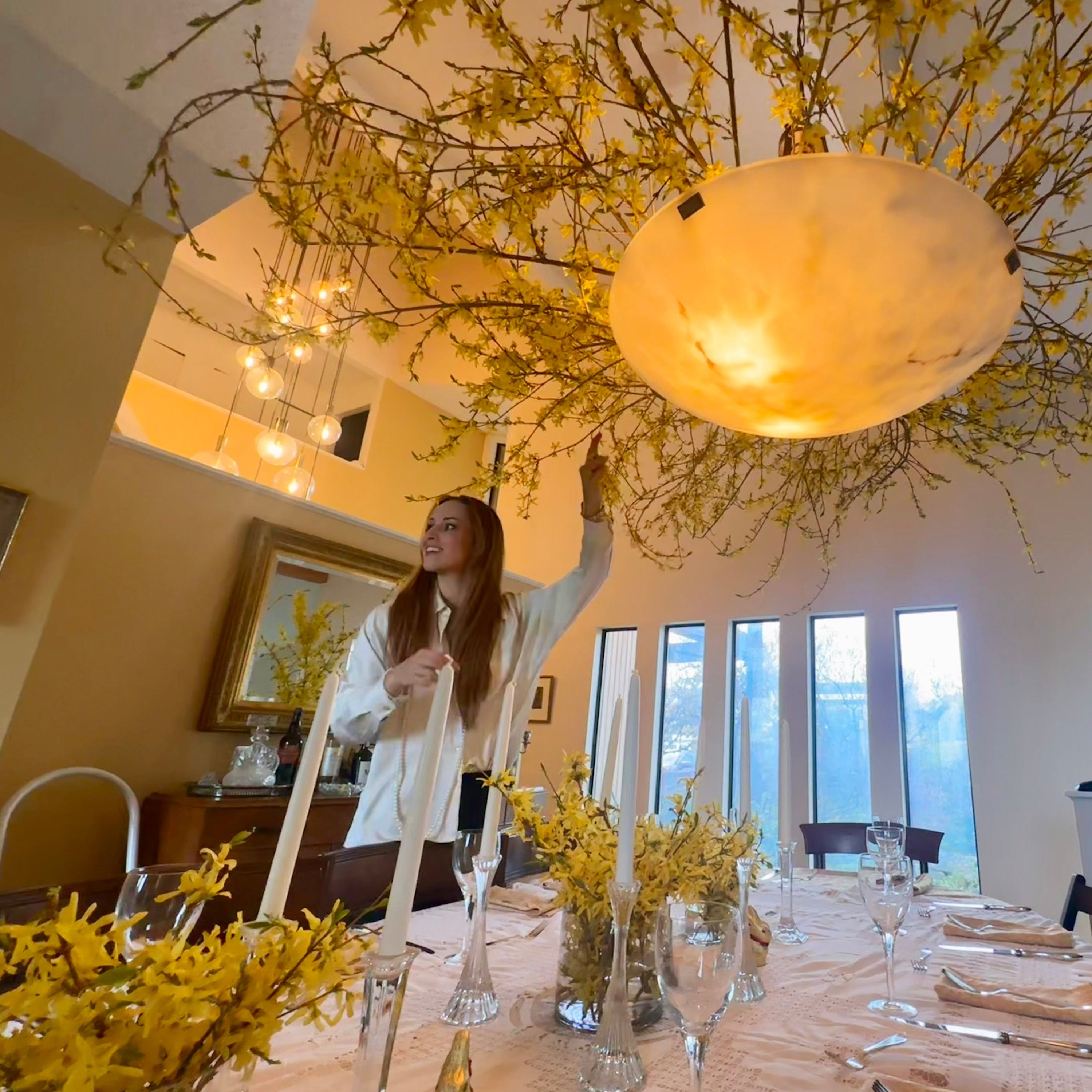 Dining room with a large chandelier and yellow floral decorations.