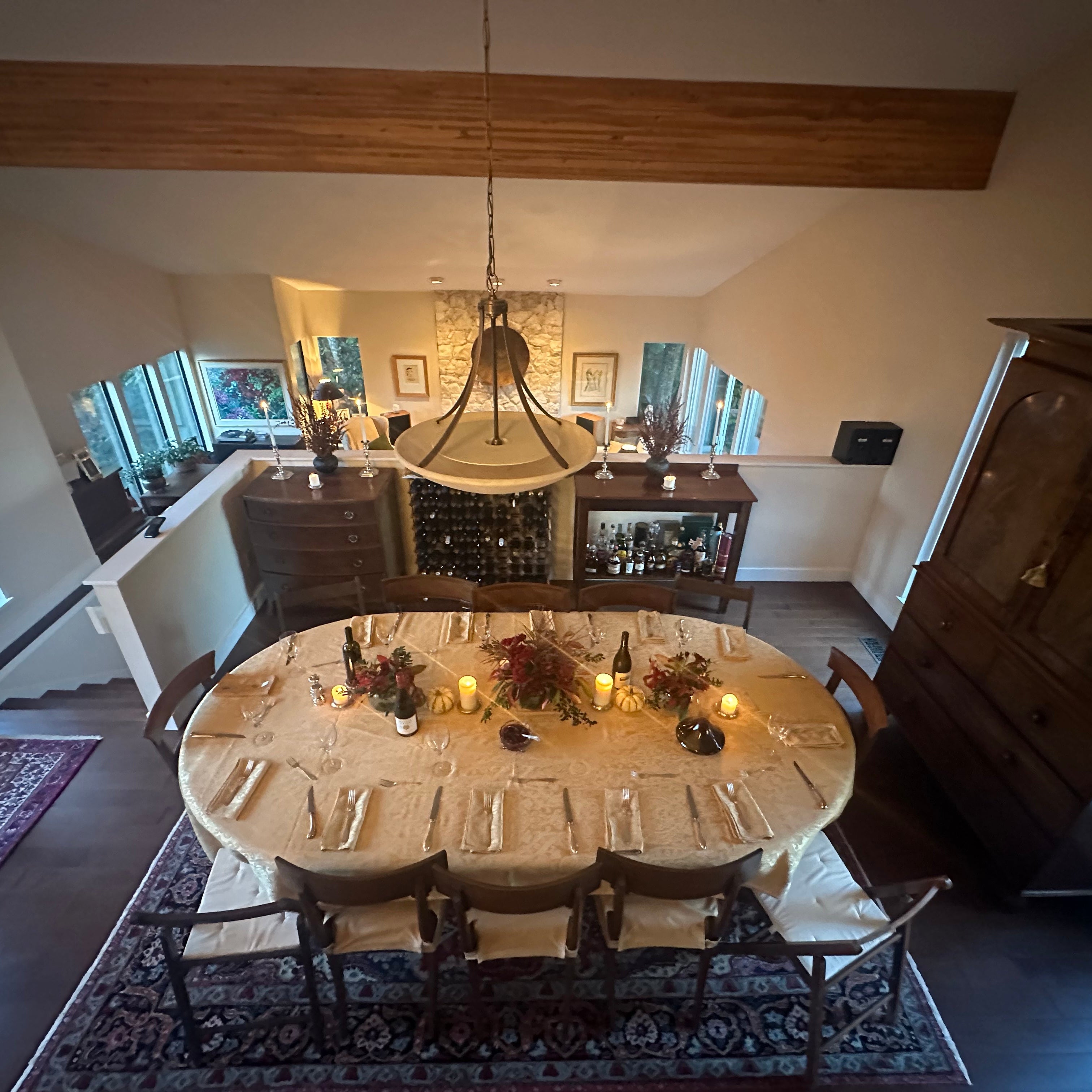 Dining room with a round table set for a meal, candles, and decorative items.