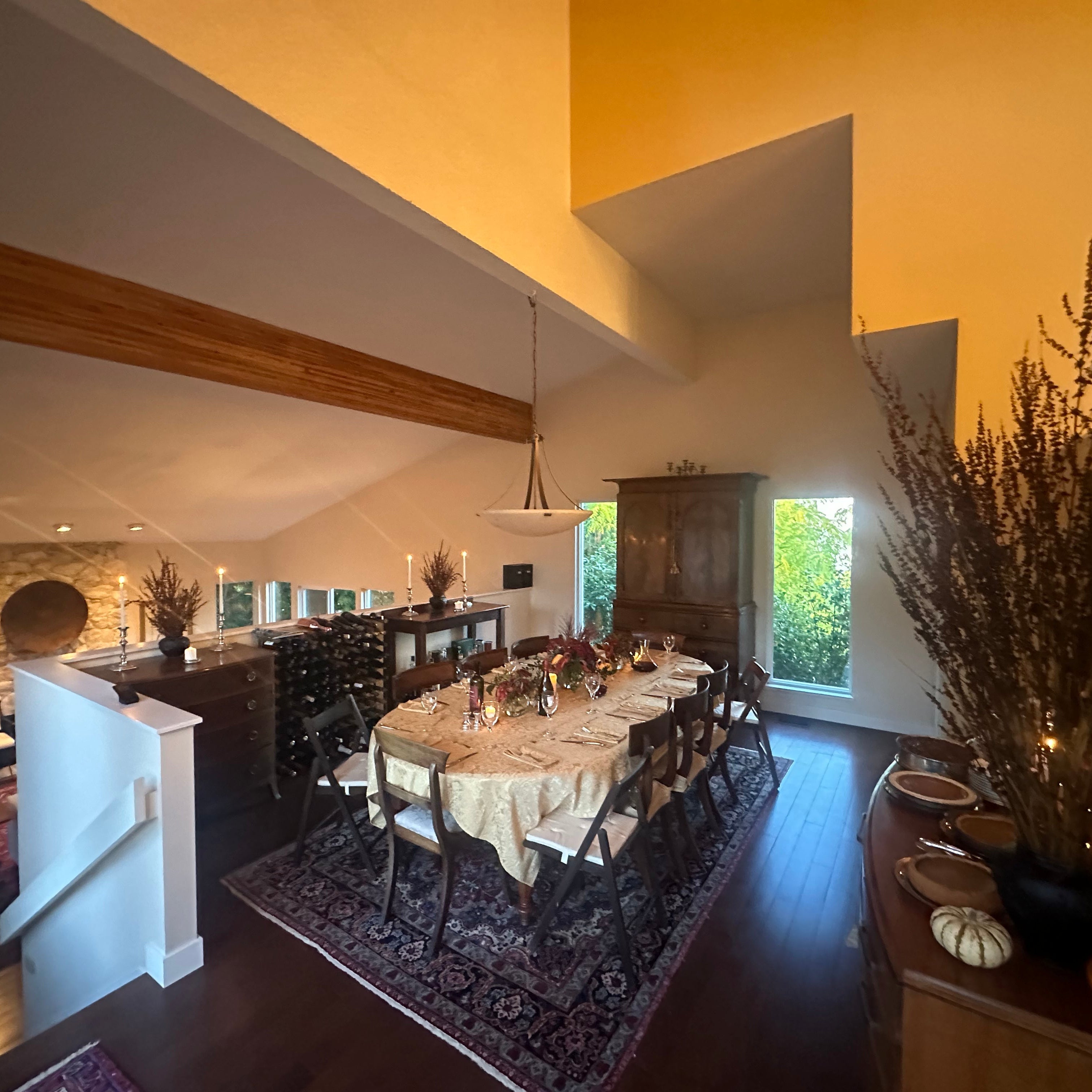 Dining room with a table set for a meal, chairs, and decorative elements.
