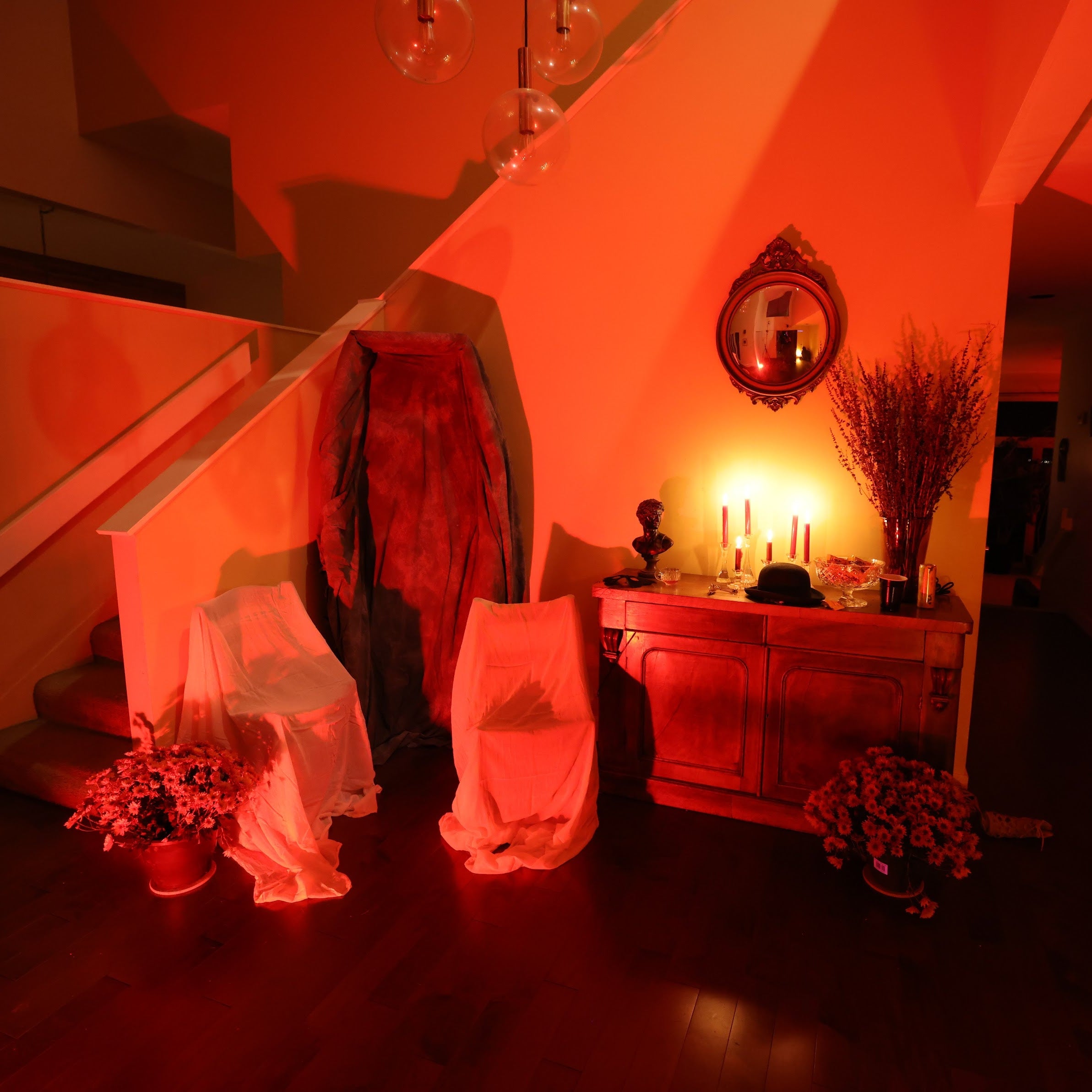 Dramatic interior scene with red lighting, draped fabrics, and decorative elements.