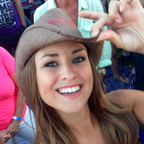 Evelyn Martin wearing a brown hat with a budweiser logo, smiling and making a peace sign as brand ambassador