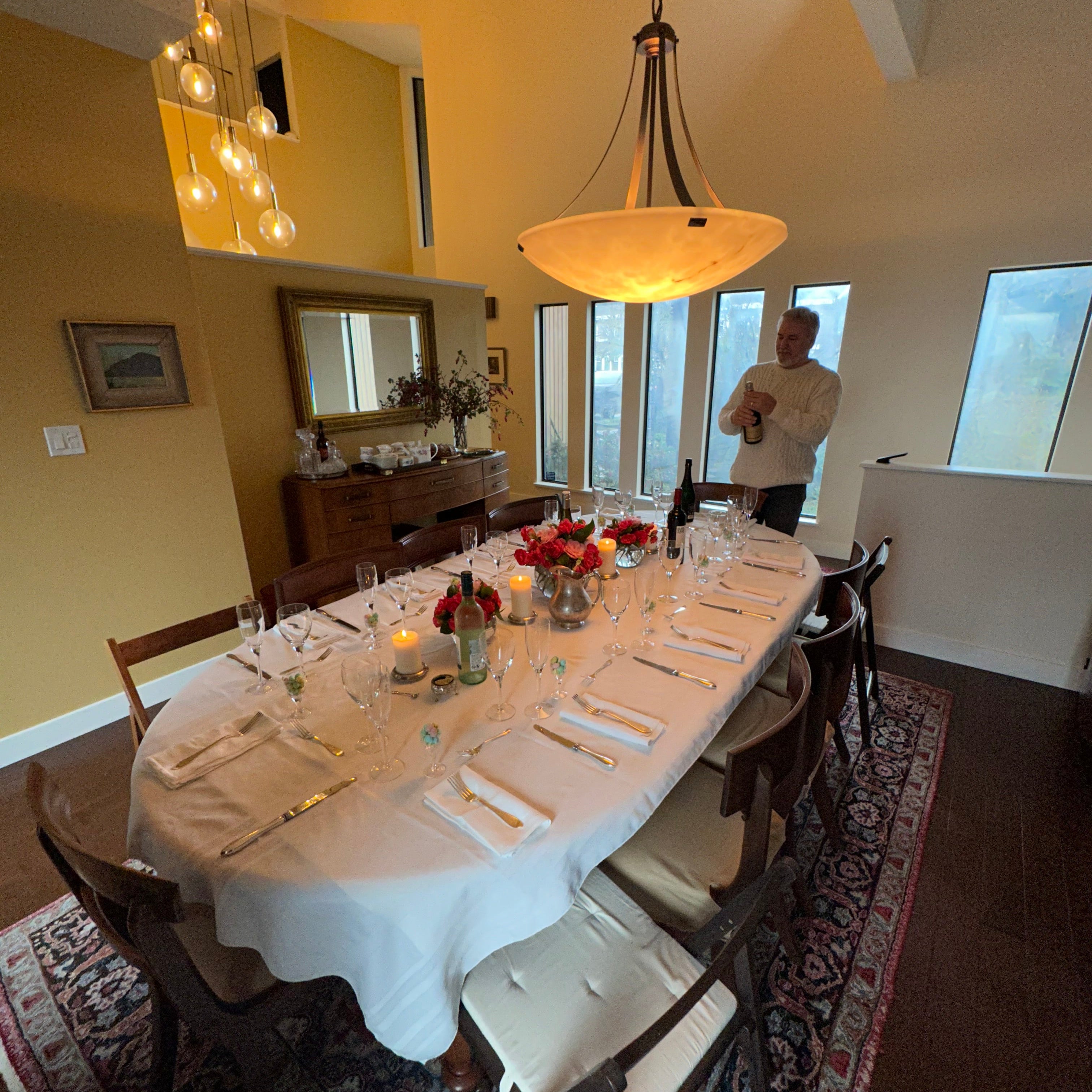 Dining room with a table set for a meal, chairs, and decorative elements.