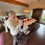 Person sitting on a couch with a bottle of wine in a living room.