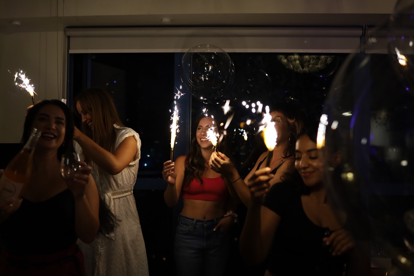 Group of people celebrating with sparklers indoors.