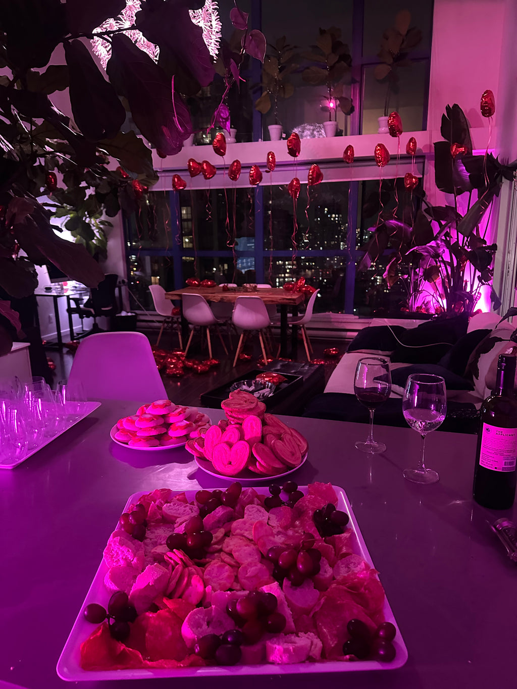 Pink-lit room with decorative elements and cityscape view