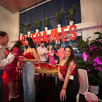 People at a party with 'Love Games' sign in the background