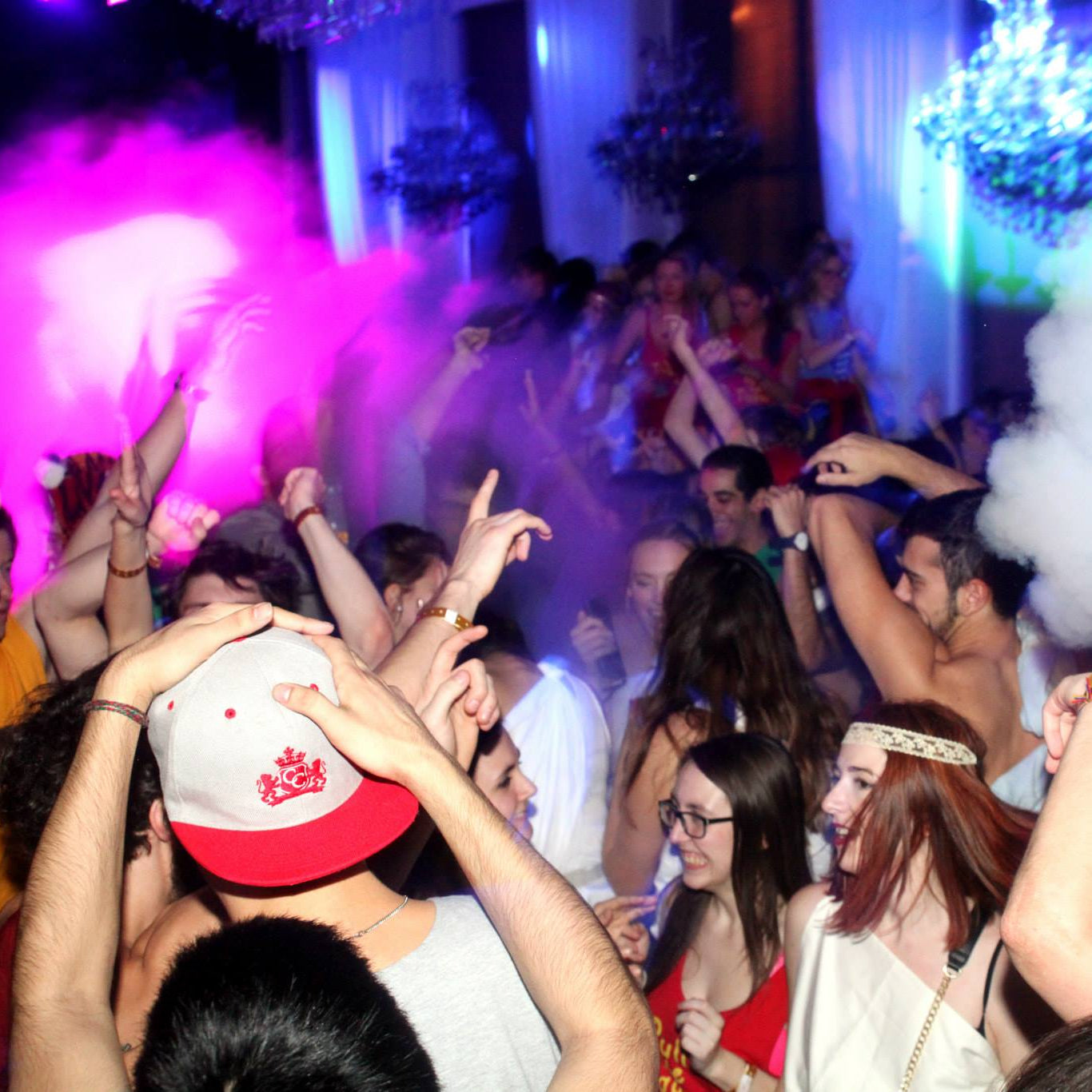 People at a party with colorful lights and smoke