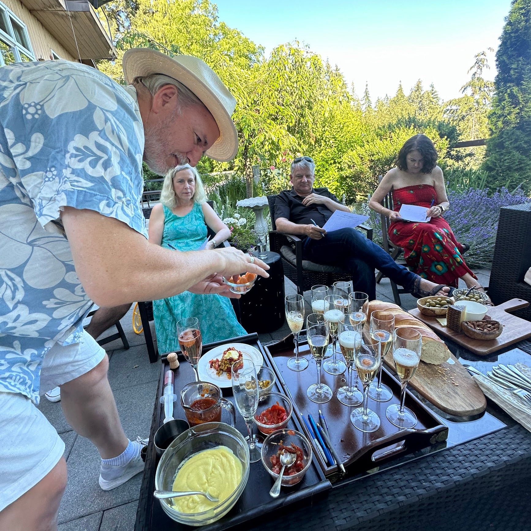People enjoying a outdoor gathering with drinks and food on a patio