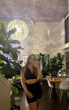 Person taking a mirror selfie in a modern interior setting with plants and decor.