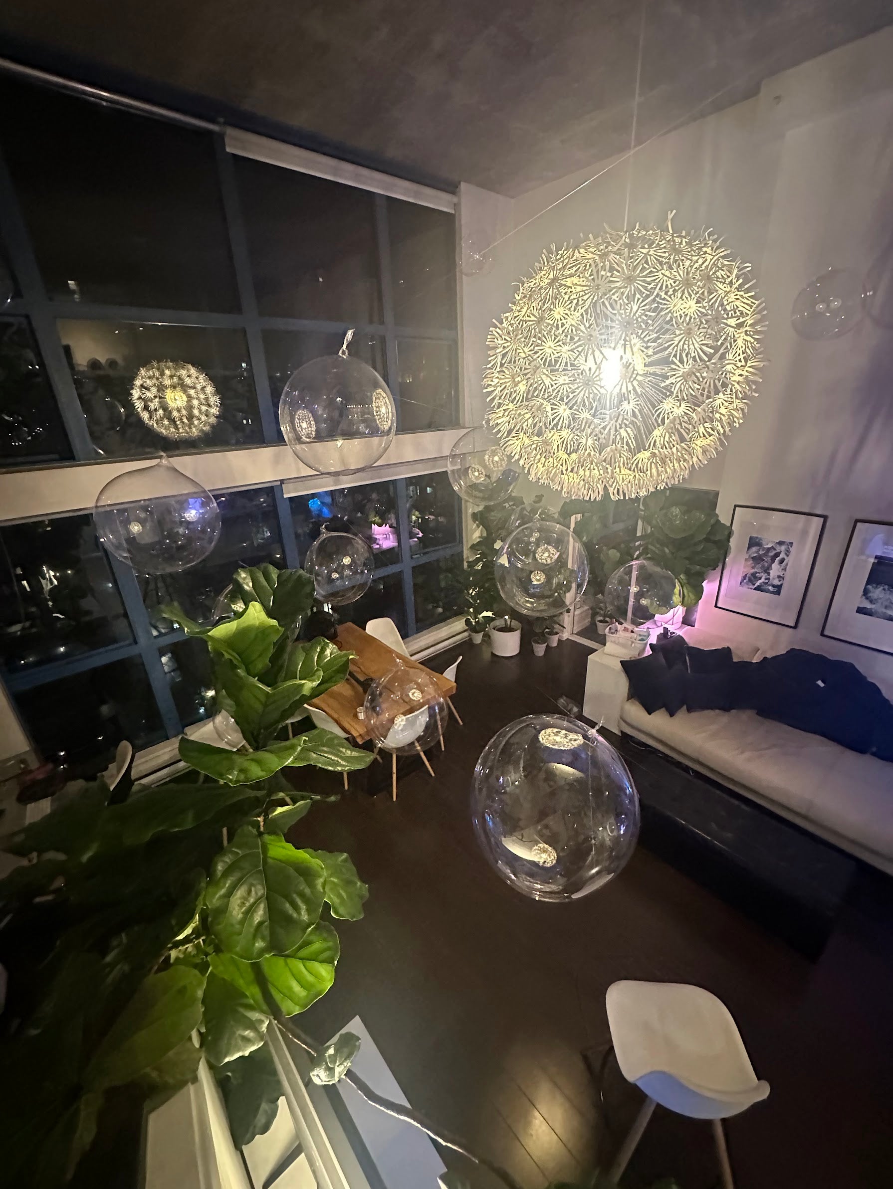 Modern living room with decorative spherical lights and plants.