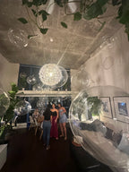 Modern interior with large spherical glass lights and people in a room.