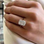 Close-up of a hand wearing a diamond ring with a blurred background