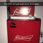 Red Budweiser refrigerator with a Budweiser sign above it on a plain background