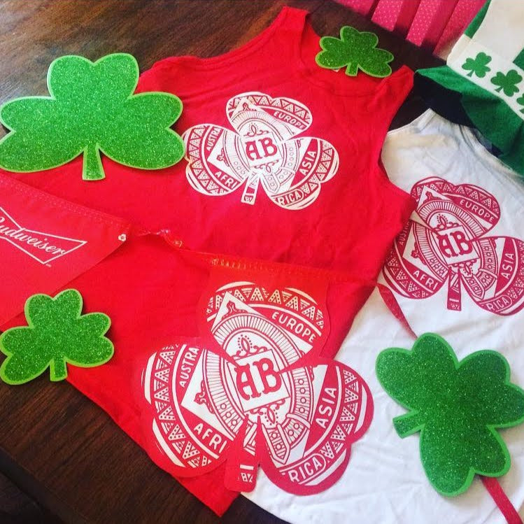Red and white underwear with Budweiser logo and green shamrock decorations on a wooden surface.