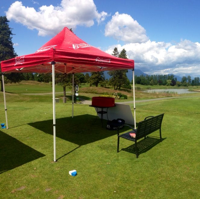 Red tent on a golf course with a scenic background