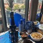 Table with snacks, drinks, and decor in front of a cityscape view.