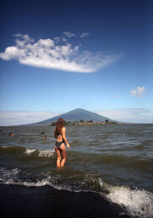 Person standing in water with a mountain in the background