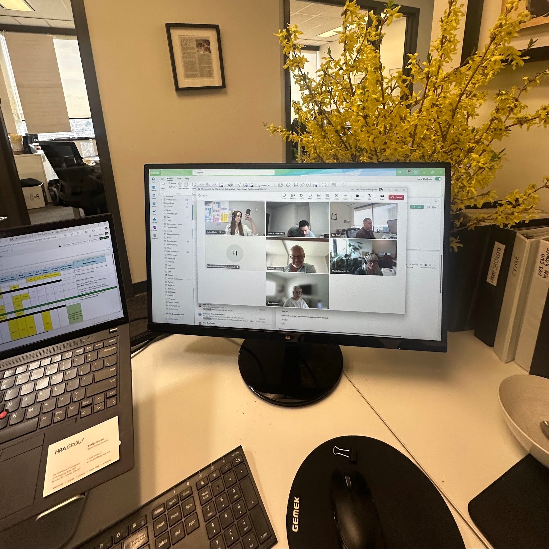 Two computer monitors on a desk with a laptop, keyboard, and mouse in an office setting.