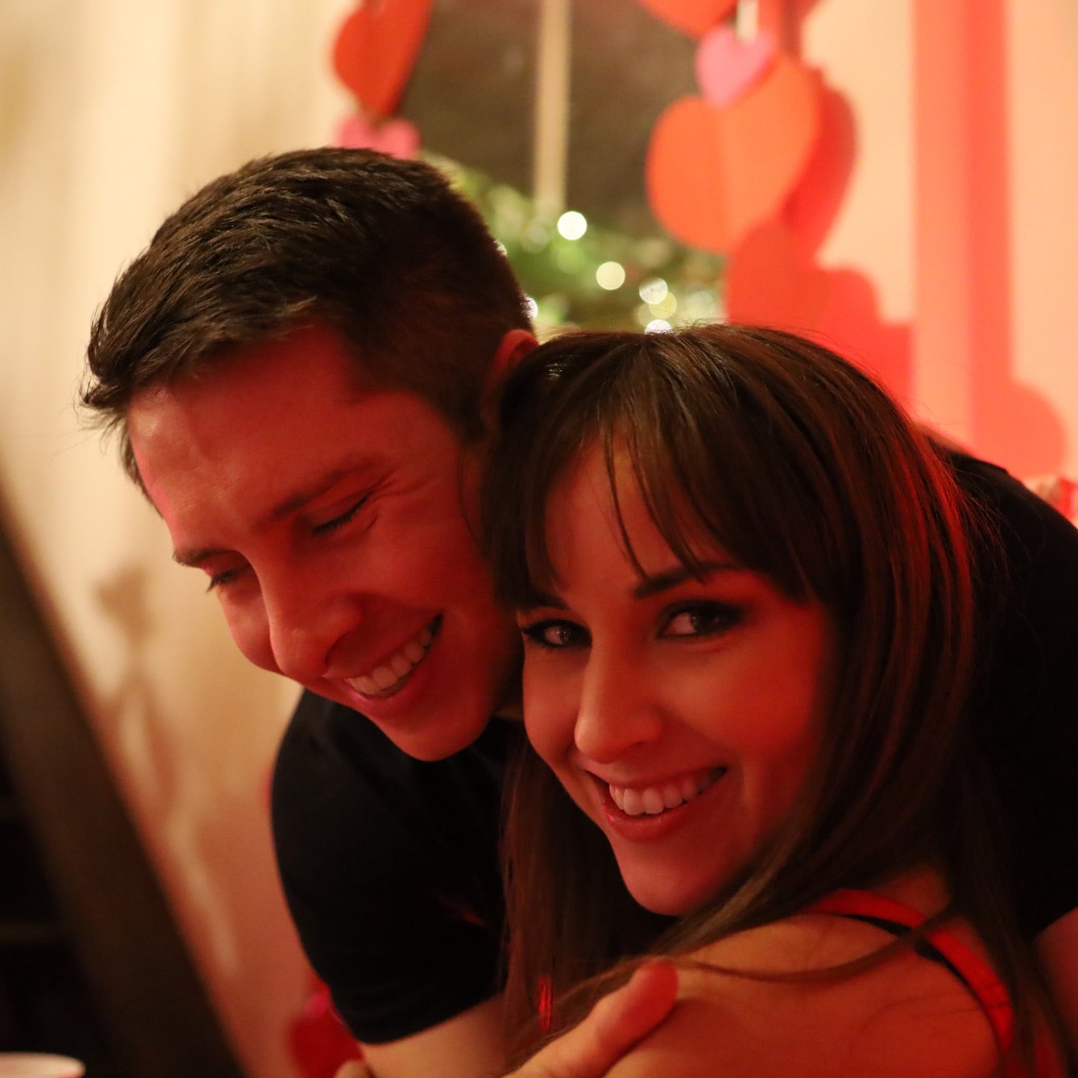 Two people smiling with a festive background