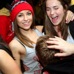 Two women in festive attire with a third person partially visible, all in a celebratory setting.