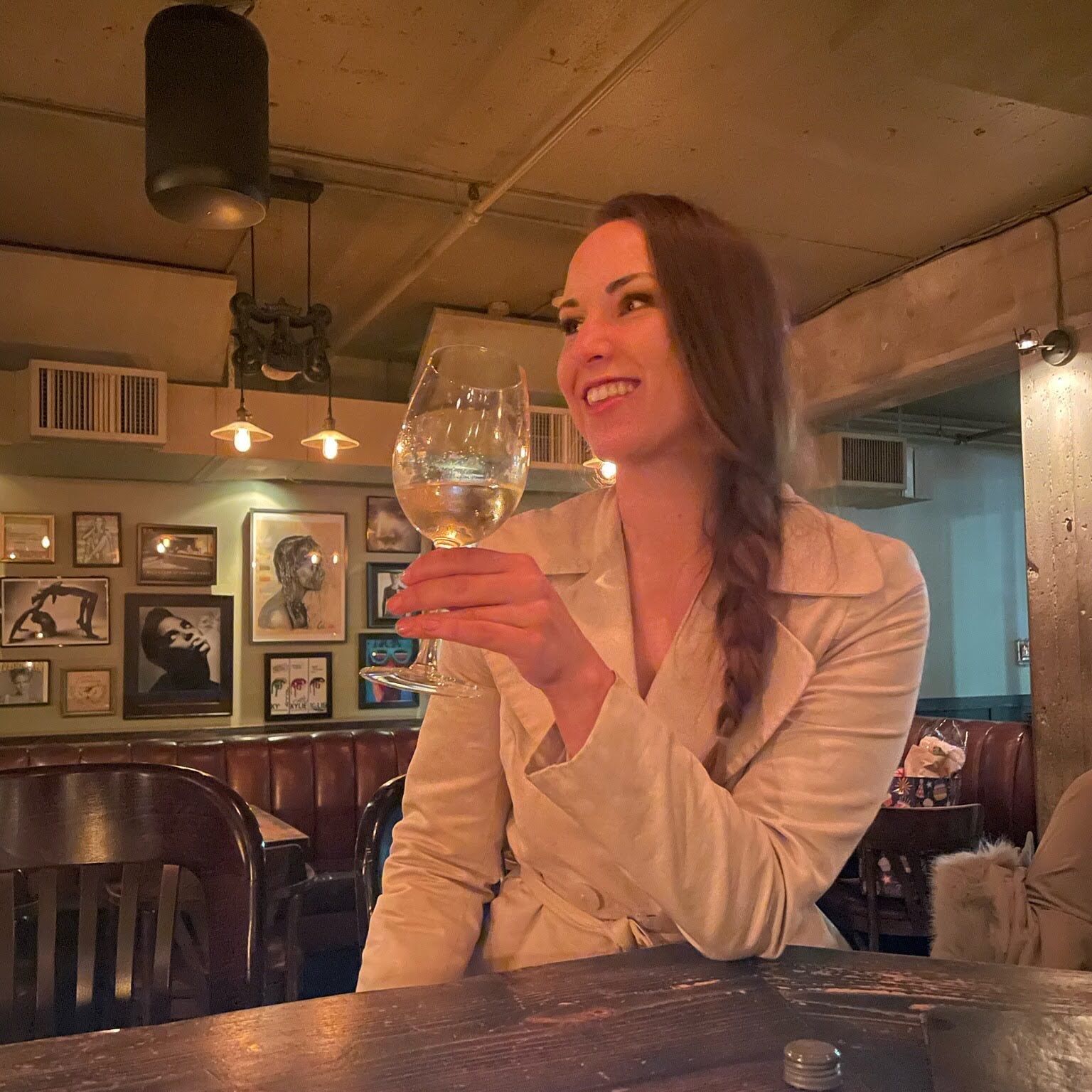 Woman holding a glass of wine in a cozy bar setting